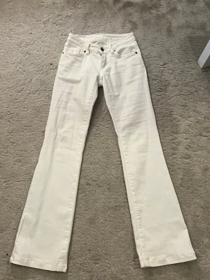 Vita bootcut jeans från Subdued - Snygga vita bootcut jeans från Subdued med klassisk femficksdesign och silverfärgade detaljer. Jeansen har normal passform och är tillverkade i bomull för en skön känsla. Perfekta att styla med en crop top eller hoodie. Uppsydda nere så passar en som är runt 155cm 