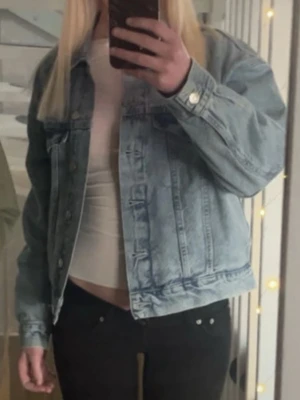 Ljusblå jeansjacka från gina  - Trendig ljusblå jeansjacka med klassisk krage och knappstängning framtill. Två bröstfickor. Perfekt att slänga över en t-shirt för en avslappnad look. perfekt nu till våren/sommaren för att piffa upp outfiten lite. Storlek XS. Endast använd 1 gång