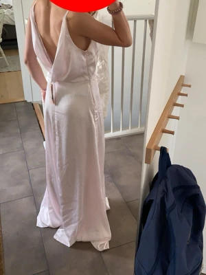 Rosa balklänning lappen kvar  - Säljer denna jättefina balklänningen med öppen rygg, använd en gång med lappen kvar. Bra skick men uppsydd så passar mig som är 162 cm. Första bilden är innan den var uppsydd och övriga efter. Skickar snabbt