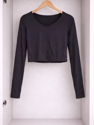 Svart croppad långärmad topp - En enkel och stilren svart croppad topp med långa ärmar och rund halsringning. Perfekt att matcha med höga jeans eller kjol för en clean look. Tillverkad i mjuk bomull som känns skön mot huden.