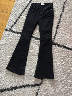 Svarta bootcut jeans från 157 - Säljer ett par svarta bootcut jeans från 157 med hög midja och klassisk femficksdesign. Jeansen har dragkedjegylf och knapp, samt är tillverkade i stretchigt denimtyg för extra komfort. Perfekta för dig som gillar en retro och trendig look. Dem är för långa och högmidjad för mig! Är 161cm och passar perfekt för dig som är 167-170cm! Har använt dem 2 gånger i skolan så är i mycket bra skick!