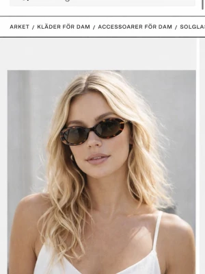 Svart bruna solglasögon från Arket - Stilrena svarta solglasögon från Arket med klassisk rektangulär form. Snygg och enkel design som passar till många olika outfits. Bågarna är i syntetmaterial och ger en modern känsla.