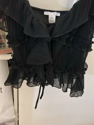 Svart volangblus från Amisu - Snygg svart blus från Amisu i storlek XXS. Har använts 1 gång❤️