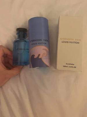 Afternoon Swim parfym från Louis Vuitton - Fräsch parfym från Louis Vuitton, Afternoon Swim, i en snygg blå glasflaska med svart kork. Flaskan rymmer 100 ml och kommer med originalförpackning och en blå cylinderformad ask med vågmotiv. Perfekt för dig som gillar exklusiva dofter. Finns 96 ml kvar 
