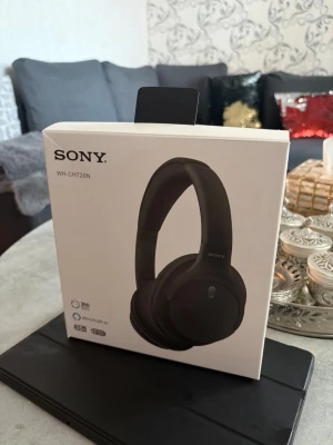 Sony WH-CH720N trådlösa hörlurar - Sony WH-CH720N är svarta, over-ear hörlurar med stilren design. De har inbyggd mikrofon, stöd för Alexa och 360 Reality Audio. Hörlurarna är trådlösa och kompatibla med iPhone och iPad. Perfekta för musik, gaming eller videosamtal.