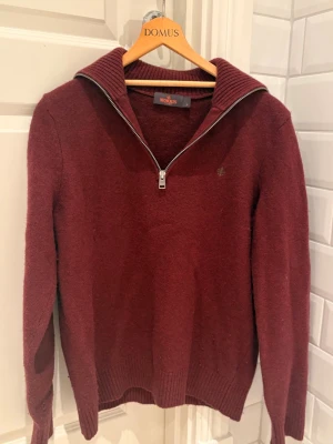 Vinröd halvzip-tröja från Morris - Vinröd stickad tröja från Morris med halv dragkedja och ribbad krage. Köpt för 1500kr, mycket gott skick. Har tyvärr krympt i tvätten så trotts att den är märkt som M passar den S. 
