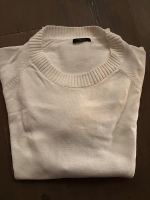 Två vita tröjor från Massimo Dutti - Säljer två stilrena vita tröjor från Massimo Dutti. Ena är stickad med bred ribbad krage och den andra är en klassisk bomullströja med rund halsringning. Perfekta basplagg till garderoben. Ena är M den andra är M/S väldigt fit passform.