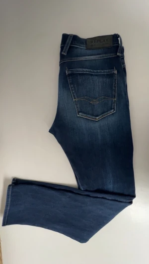 Mörkblå skinny jeans från Replay - Snygga mörkblå skinny jeans från Replay med klassisk femficksdesign och kontrastsömmar på bakfickorna. Jeansen har en smal passform och är tillverkade i stretchigt denimtyg för extra komfort. Perfekta till en avslappnad streetstyle-look. 