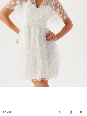 Vit klänning med blommor - Säljer min oanvända vita klänning från bubbleroom eftersom jag köpt en ny till studenten. Den är i storlek 34 och prislappen sitter kvar. 