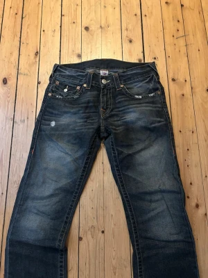 True Religion jeans  - säljer mörkblå jeans får True Religion. tyvärr trasiga ner till men det är ganska snyggt med det 