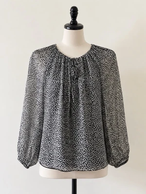 Svartvit mönstrad blus 100% silke Diane von Furstenberg - Snygg svartvit blus i 100% silke från Diane von Furstenberg med abstrakt mönster. Blusen har rund halsringning med liten knytning. Långärmad modell med volym i ärmarna och avslappnad passform. Storlek S