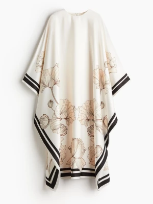 Hm kaftan med blommor - Cremefärgad kaftan med beiga blommor och svarta streck. Rymlig i storleken. Storlek XS/S helt ny med lapp 