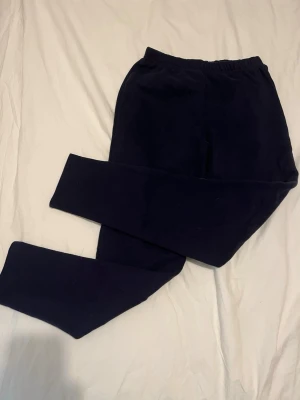 Mörkblå mjukisbyxor med resårmidja - Mörkblå mjukisbyxor/ underställ med rak passform och resår i midjan. Tillverkade i ett mjukt och bekvämt material som passar perfekt för chill dagar. Klassisk enkel design utan synliga loggor eller detaljer. Tjockare material som är underställs material men funkar också bra som mjukisar💕 
