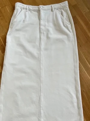 Gina Tricot Beige  långkjol  - långkjol i klassisk jeansmodell med fickor fram och bak  och på en sida samt hällor för bälte. erfekt för en clean och stilren look. Sista bild är lånad 