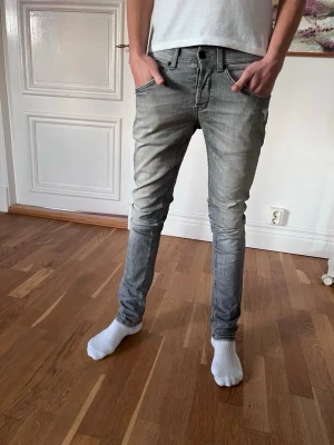 Grå Dondup George jeans - Säljer nu ett par riktigt snygga och eftertraktade grå Dondup jeans i den populäraste modellen George. Jeansen har bara använts fåtal gånger och har fortfarande mycket att ge. Nypris ligger runt 3500 men jag säljer endast för 899kr. Storlek  w30.