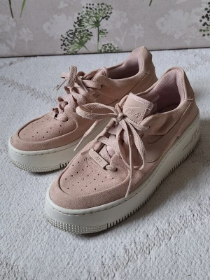 Nike Air Force 1 rosa sneakers - Nike Air Force 1 sneakers i ljusrosa mocka med vita, tjocka sulor.