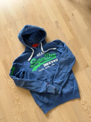 Superdry hoodei - Säljer en riktigt fet superdry hoodie i storlek S den är helt utan skavanker och i allmänt bra skick. Vid frågor om bilder eller liknande så är det bara att fråga💛😊