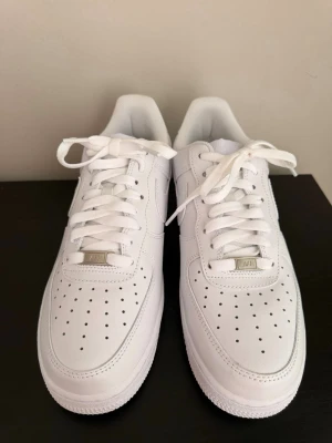 Nike Air Force 1 vita sneakers - Splittarsnya vita Air force 1s, som ni ser på bilden så har den inte använts en enda gång och är i pristin skick. Storlek 44 hör av dig om du är intresserad!