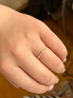 Tunn silverring med små stenar - Snygg och tunn silverfärgad ring med fem små klara stenar i rad framtill ifrån Thomas Sabo. Ringen har en minimalistisk och elegant design som passar perfekt för dig som gillar diskreta smycken som är gulliga. Materialet är sterling silver. Orginalpriset-569kr. STORLEK : 17mm