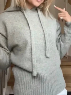 Ljusgrå hoodie med huva - Mysig ljusgrå hoodie med huva och dragsko. Tillverkad i ett mjukt stickat material med ribbade muddar vid ärmslut och nederkant. Perfekt för en avslappnad och trendig look.