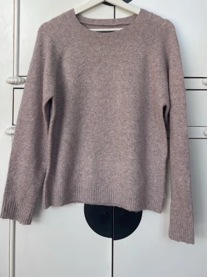 Beige/rosa stickad tröja - Mysig beige/rosa stickad tröja med rund halsringning och långa ärmar. Tröjan har ribbade muddar vid ärmslut och nederkant, och är tillverkad i polyester elastan och nylon. Perfekt för en kylig sommarkväll. Passar som storlek s men är storlek m💞