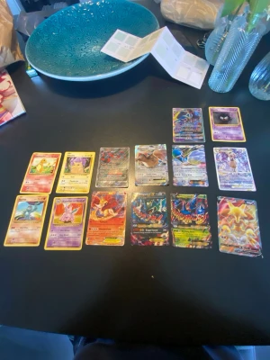 Samling Pokémonkort blandade typer - Säljer en samling Pokémonkort med olika motiv och färger, inklusive flera holografiska och EX/V-kort. Bland korten finns populära Pokémon som Rayquaza, Delphox och Pidgeot. Perfekt för dig som vill utöka din samling eller börja spela Pokémon TCG.