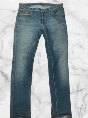 Nudie Jeans - Blå Nudie Co Jeans. Behöver strykas lite men annars mycket bra skick. Storlek W30/34L. Priset är ej slaget i sten! Skriv gärna om du har frågor eller vill ha en detaljerad bild.
