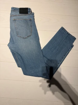 Ljusblå raka jeans från Weekday - Säljer ett par ljusblå jeans från Neuw med rak passform och klassisk femficksdesign. Jeansen har hög midja och är tillverkade i 100% bomull för en skön vintagekänsla. Perfekta till vardagslooken och lätta att styla med sneakers eller boots.