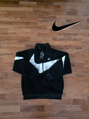 Nike Reversibel Jacka - 🖤 Nike Reversible Sherpa Jacket – Storlek XL 🖤 Varm och stilren Nike-jacka med reversibel design som ger två looks i ett. Ena sidan i mjuk sherpa-fleece för värme och komfort, andra sidan i slät sportig Nike-stil för en clean streetwear-look. Full zip, hög krage och loose fit-passfom. Perfekt för höst och vinter eller lager-på-lager outfits. 📦 Snabb leverans – skickas samma dag (om ej hindr.) 📩 Kontakta vid frågor.