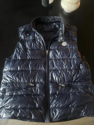 Mörkblå dunväst från Moncler - Säljer en äkta mörkblå moncler gui i storlek 4 (passar en M/L)  Perfekt nu i sommar!                                                                             Inga skador eller liknande och skriv för mer bilder eller frågor