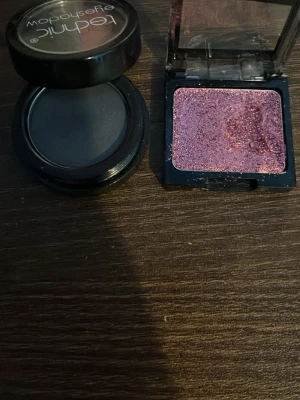 Technic svart och wet n wild  lila ögonskugga - Två ögonskuggor: en matt svart i rund dosa från Technic och en skimrig lila i fyrkantig dosa. Perfekta för att skapa både dramatiska och kreativa ögonlooker. Kommer i praktiska plastförpackningar med lock. Den rosa är från wet n wild 