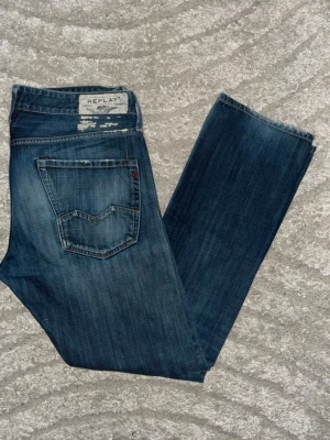 Replay Waitom jeans  - Mörkblåa Replay Waitom Jeans med fade. Obs jeansen har två hål, knät och höger ficka. Midja 48cm, längd 109cm. Bilden är inlånad för att visa hur passformen sitter. Jag har ingen bild när jag bär jeansen på. För bättre inblick i passformen rekommenderar jag att googla på modellnamnet. För storleksguide kolla måtten noggrant då jeansen alltid kan vara uppsydda heller krympta och jag ej tar emot returer :) 1,85