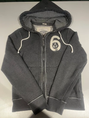 Abercrombie & fitch zip hoodie (sällsynt) - Riktigt snygg och eftertraktad Abercrombie fitch zip hoodie. fint skick inga fel storlek M kan ta mått vid behov. Endast 425kr ej hugget i sten kom gärna med frågor och prisförslag har även mycket mer liknande i min profil alla storlekar kolla gärna stor rabatt vid köp av flera 😁✌️