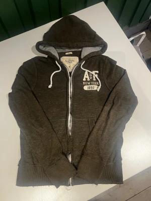 Abercrombie & fitch zip hoodie vintage  - Riktigt snygg Abercrombie & fitch zip hoodie. fint skick inga fel storlek M kan ta mått vid behov. Endast 395kr ej hugget i sten kom gärna med frågor och prisförslag har även mycket mer liknande i min profil alla storlekar kolla gärna stor rabatt vid köp av flera 😁✌️