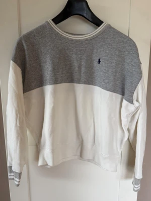 Gråvit sweatshirt från Polo Ralph Lauren - Snygg sweatshirt i grått och vitt från Polo Ralph Lauren. Stl. XL/TG (16 år). Köparen betalar frakt.