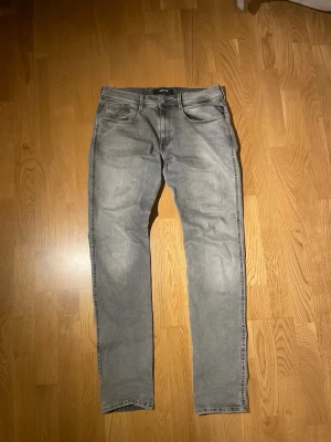 Replay Anbass Jeans - Jeans från Replay i modellen Anbass som är slim fit. Jeansen är i mycket bra skick bortsett från den defekt som visas på bild 4, därav den billiga prislappen. Storleken är 33/34.