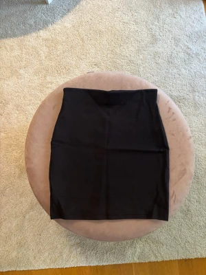 Svart tight kjol från Cubus - Säljer en svart tight kjol från Cubus i storlek XS. Men funkar som S. Kjolen har en enkel och stilren design med kurvig passform och är perfekt för att matcha med olika toppar. Materialet känns mjukt och stretchigt vilket gör den bekväm att bära.