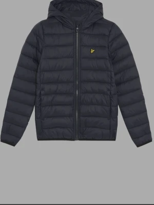 Svart pufferjacka från Lyle & Scott - Snygg svart pufferjacka från Lyle & Scott med huva och dragkedja framtill. Jackan har ett quiltat mönster och den klassiska gula loggan på bröstet. Perfekt för kalla dagar och håller dig varm med sin vadderade design.