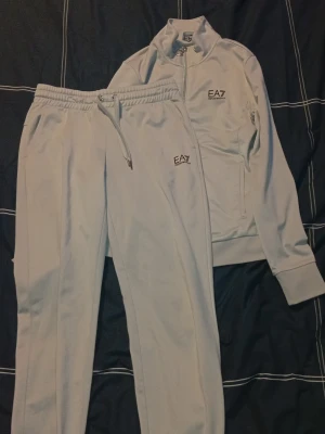  EA7 set - Säljer ett riktigt cleant vitt tracksuit-set från EA7 Emporio Armani i storlek S. Setet är i mycket bra skick och knappt använt.  Perfekt om du vill ha något fräscht och enkelt att matcha - vitt går alltid hem.  Säljs pga används inte längre.   Hör av dig vid frågor eller fler bilder!