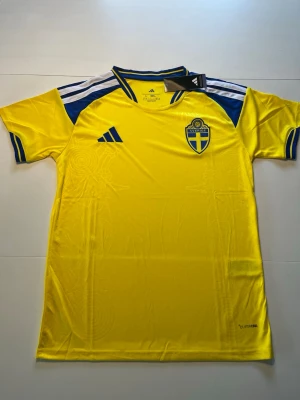 Sverige fotbollströja  - En Sverige fotbollströja 2026 aldrig använd. Perfekt för dig som inte hunnit köpa in din Sverige tröja inför vm än. Tröjan är i storlek large utan namn så riktigt stilren. Kom gärna med frågor eller funderingar.