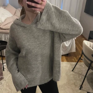 Grå stickad hoodie med vida ärmar - Mysig grå stickad hoodie med avslappnad passform och vida ärmar. 