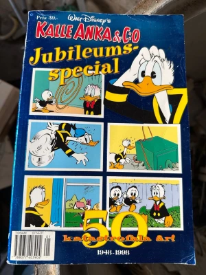 Kalle Anka & Co Jubileumsspecial - Kalle Anka & Co Jubileumsspecial – en färgglad serietidning med blått omslag och klassiska serierutor med Kalle Anka och hans brorsöner. Utgiven för att fira 50 katastrofala år, 1948-1998. Perfekt för dig som älskar nostalgi och Disney.