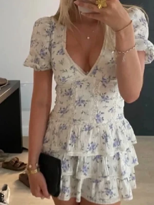 Trendig Zara Klänning  - Ge gärna prisförslag!! Supersöt kortklänning med puffärmar, djup v-ringning och flera volanglager. 💐Klänningen är vit med blå blommor, har en feminin passform och är perfekt för sommarens tillfällen. ❣️ 