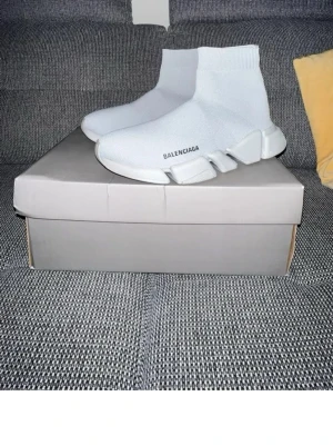 Vita Speed Trainer sneakers - Säljer ett par vita  Speed Trainer sneakers med stickad ovandel och chunky sula. Skorna har en strumpliknande passform och logga på sidan. Perfekta för dig som gillar en clean och futuristisk stil.