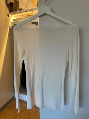 Intimissimi, Vit långärmad topp i bomull - En enkel och stilren vit långärmad topp med rund halsringning. Toppen är i mjukt bomullsmaterial och har en slim passform som sitter snyggt på kroppen. Perfekt att matcha med jeans eller kjol.