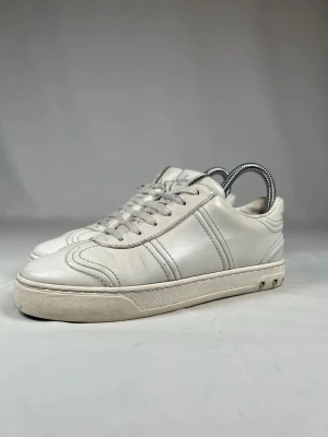 Vita valentino  - Stilrena vita sneakers från valentino garvani  i mjukt läder. Klassisk låg modell med vita snören och diskreta sömdetaljer längs sidorna. Tidlös design som passar till det mesta och ger en clean look.