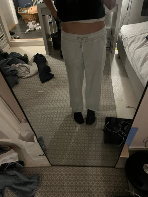 Ljusa mjukisbyxor med dragsko - Säljer ett par ljusgrå mjukisbyxor med raka ben och dragsko i midjan. Byxorna har en relaxed fit och är perfekta för chill dagar. Tillverkade i mjukt material som känns skönt mot huden. Passar dig som gillar en enkel och clean stil.