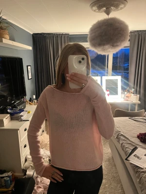 Ljusrosa stickad tröja - Säljer en ljusrosa stickad tröja med rund hals och långa ärmar. Tröjan har en enkel och avslappnad passform, perfekt för att slänga på sig till jeans eller leggings. Materialet är mjukt och tunt, vilket gör den skön att bära inomhus eller under en jacka.