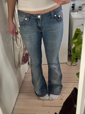 Blå bootcut jeans från True Religion - Säljer de populära True religion jeansen. De är blåa med mörkröd söm. Jeansen har låg midja.