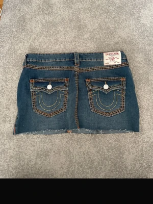 Jättefin true religion minijeanskjol - Säljer en asnice blå jeanskjol från True Religion med coola stygn, modell Sadie Mini Skirt. Är storlek 30 vilket motsvarar ca M. Kan förhandla om priset vid en snabb affär! Skriv om du har några frågor jag svarar snabbt🥰🥰